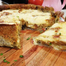 Tarta de berenjenas en masa de semillas con cubierta de cebolla y queso